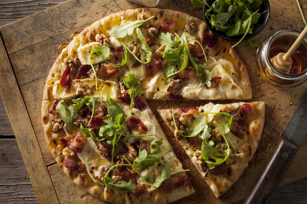 Stonefire Pizza crust topped with arugula, walnuts, bacon, brie and honey.