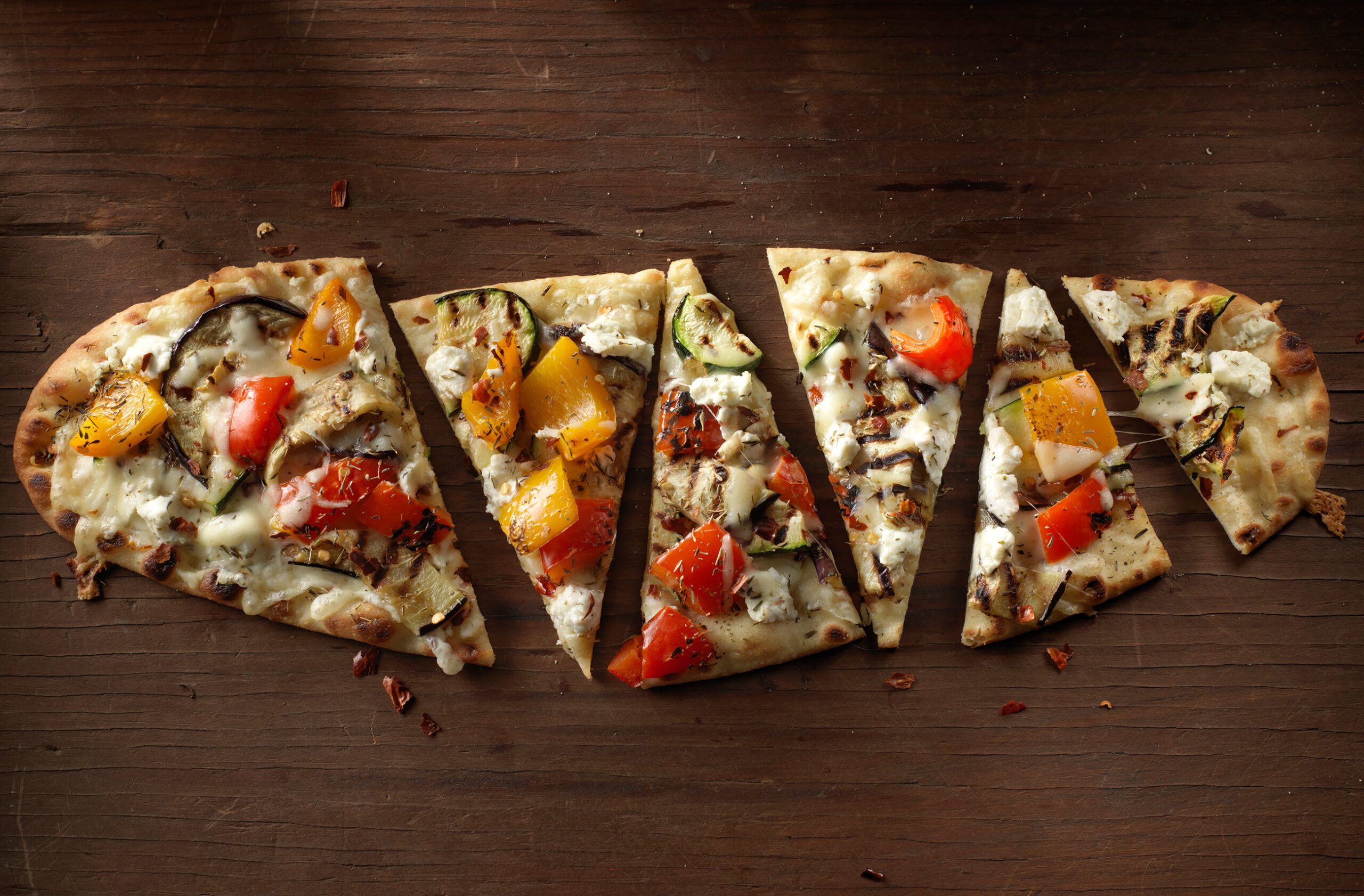 Stonefire Flatbread with grilled veggies. Set in a dark wooden background